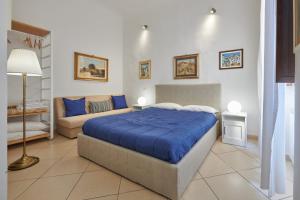 a bedroom with a blue bed and a couch at Florence&Us Santa Croce in Florence