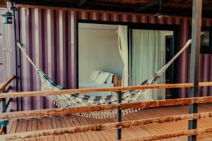a hammock in a room with a bed at Villa Container Lodge in Capitólio