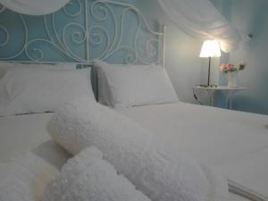 een slaapkamer met een wit bed met een blauw hoofdeinde bij Morfi in Lefkada