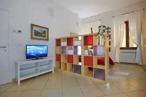 a living room with a television and a book shelf at Florence&Us Santa Croce in Florence
