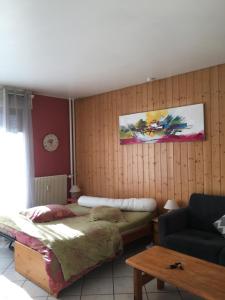 een slaapkamer met een bed en een bank bij Au pieds des 3 vallées in Brides-les-Bains