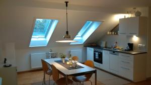 cocina con mesa y sillas y algunas ventanas en Stilvolle Ferienwohnung am Großen Garten, en Dresden