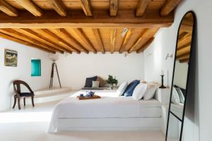 a bedroom with a bed and a wooden ceiling at The Vasilicos in Imerovigli