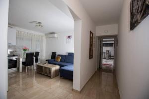 uma sala de estar com um sofá azul e uma mesa em Apartment Mattias free private parking em Mostar