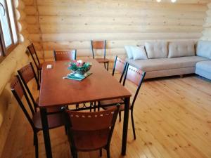 een kamer met een tafel, stoelen en een bank bij Cottage house Niniela in Batoemi