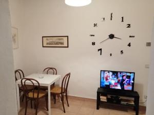 a dining room with a table and a clock on the wall at Casa Anna in Siena