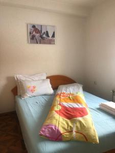 a bedroom with a bed with a colorful blanket on it at Villa Anastasoski in Mavrovo