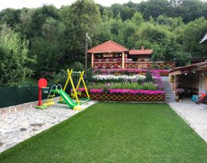 un jardín con parque infantil y una casa con flores en Villa Anastasoski, en Mavrovo