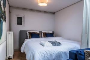 um quarto com uma grande cama branca com almofadas azuis em Meeuwen Manor em Edam