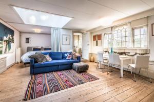 uma sala de estar com um sofá azul e um quarto em Meeuwen Manor em Edam