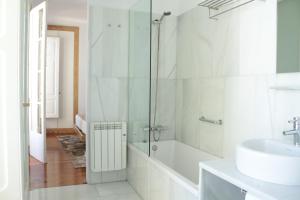 uma casa de banho com um chuveiro, um lavatório e uma banheira em Hotel Pazo de Altamira em Santiago de Compostela