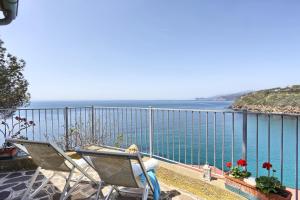 un par de sillas sentadas en un balcón con vistas al océano en Rosa dei Venti, en Capoliveri