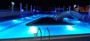 una piscina notturna con ponte di Girni Gold Apartments,Petković a Olympiakí Aktí