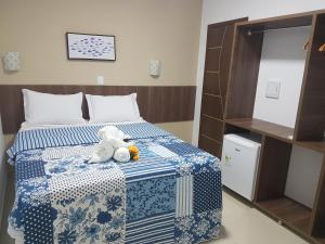 ein Schlafzimmer mit einem Bett mit einem Teddybär drauf in der Unterkunft Pousada Gamela do Maragogi in Maragogi