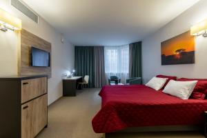 a hotel room with a red bed and a desk at Favor Sport Hotel in Kyiv