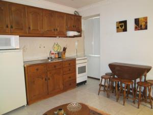 a kitchen with wooden cabinets and a sink and a table at Casa Das Lages in Alvoco da Serra