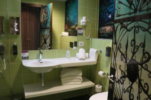a bathroom with a sink, toilet, and mirror at Gardaland Magic Hotel in Castelnuovo del Garda