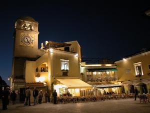 un bâtiment avec une tour d'horloge et une foule de gens dans l'établissement Esperidi Resort, à Sant'Agnello