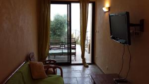 a living room with a tv and a sliding glass door at Castelia in Lumio