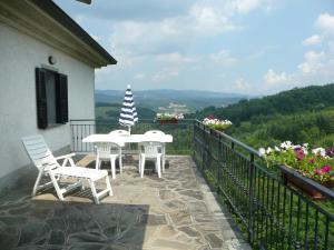 eine Terrasse mit einem Tisch und Stühlen auf dem Balkon in der Unterkunft Casa Pastano in Tornolo