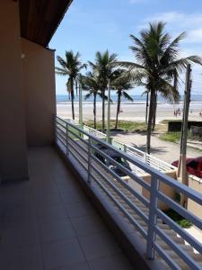 balcón con vistas a la playa y a las palmeras en Linda Casa pé na areia em Mongagua, en Mongaguá