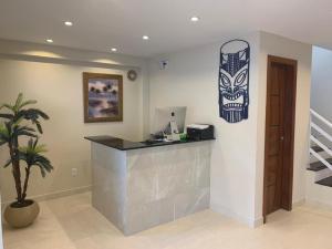an office with a counter with a mask on the wall at Pousada Arraial Tropical in Arraial do Cabo +79 photos