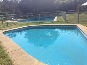 ein großer Pool mit blauem Wasser auf einem Feld in der Unterkunft Cabañitas Remanso, baño privado in Isla de Maipo