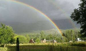 a rainbow over a field with at Casa Sur in El Bolsón