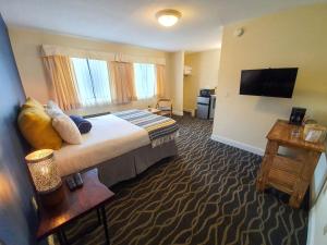 a hotel room with a bed and a flat screen tv at PIER BLUE INN Old Saybrook - Essex in Old Saybrook