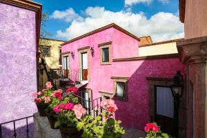 サンミゲル・デ・アジェンデにあるEl mesón del Quijoteの花の咲くピンクの建物