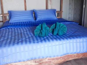 a blue bed with blue sheets and blue pillows at Blue Sky Bungalow in Ko Jum +27 photos