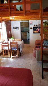 a living room with a table and a kitchen at Casa Sur in El Bolsón