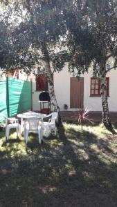 ein Picknicktisch und zwei Stühle unter einem Baum in der Unterkunft Casa Sur in El Bolsón