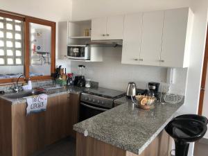a kitchen with white cabinets and a granite counter top at PARADISE EN VICHAYITO II in Vichayito
