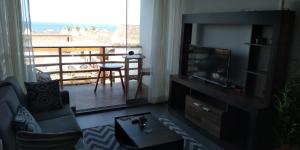 a living room with a television and a balcony at PARADISE EN VICHAYITO II in Vichayito