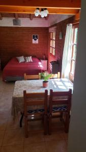 a room with a table and a bedroom with a bed at Casa Sur in El Bolsón