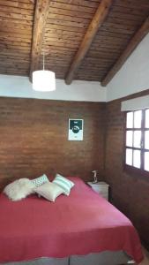 a bedroom with a bed with a red blanket at Casa Sur in El Bolsón