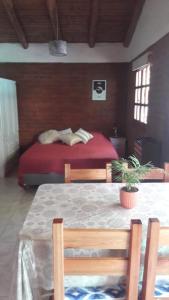 ein Schlafzimmer mit einem Bett und einem Tisch mit einer Pflanze in der Unterkunft Casa Sur in El Bolsón
