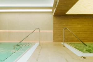 una piscina con vasca idromassaggio in un edificio di Hotel Ginkgo a Hódmezővásárhely