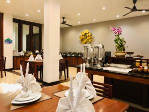 a dining room with a table and a kitchen at Sabaidee@Lao Hotel Vientiane in Vientiane