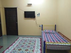 a bedroom with a bed and a tv on the wall at Homestay Teratak Umi Klang in Klang