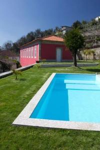 una piscina azul en la hierba con un edificio en Casa de Lemos en Sobradelo da Goma