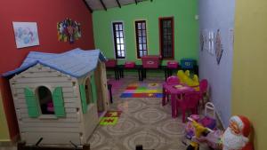 una sala de juegos con una casa de juguetes y una mesa en Pousada Ferradura Beach, en Búzios