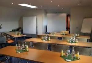 ein Zimmer mit mehreren Tischen und Gläsern darauf in der Unterkunft Hotel Auerhahn in Pulheim