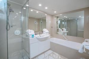 W łazience znajduje się wanna, umywalka i prysznic. w obiekcie Dorchester On The Beach w mieście Gold Coast
