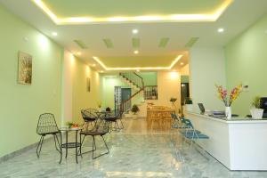 a lobby with chairs and a table and a staircase at Lam Garden Boutique Homestay in Hue
