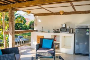 a kitchen and living room with chairs and a refrigerator at baanchandra in Chiang Mai