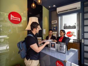three people standing at a counter in a coffee shop at The Bed KLCC in Kuala Lumpur +46 photos