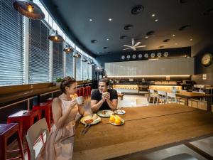 un hombre y una mujer sentados en una mesa en un restaurante en The Bed KLCC en Kuala Lumpur