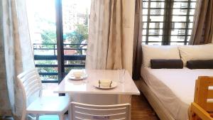 um quarto com uma mesa, uma cama e uma janela em Mireya's Studio Condo at Goshen Towers - Session Road em Baguio